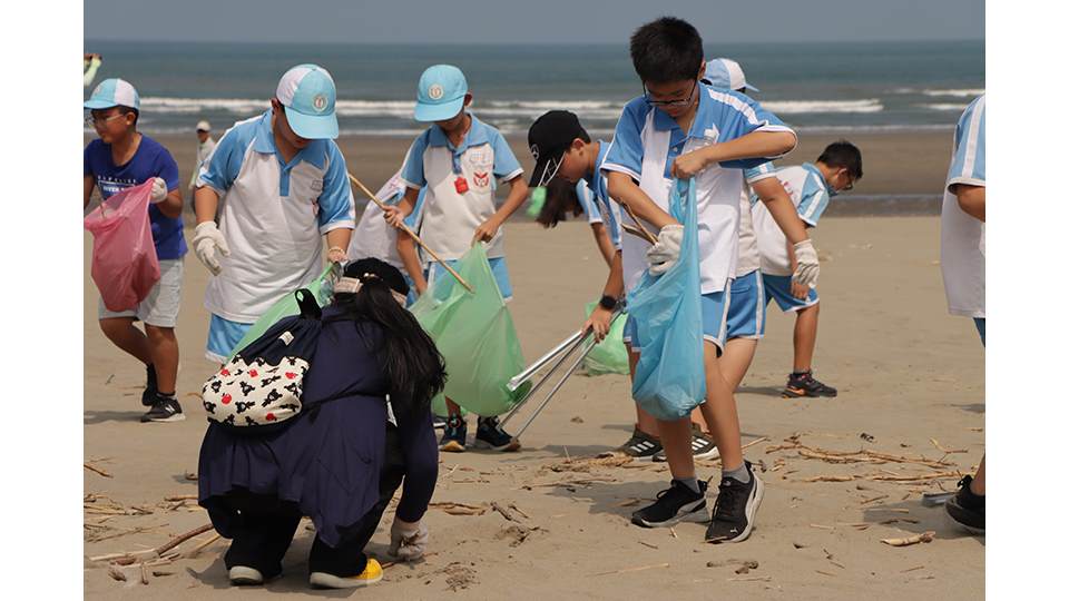 參與淨灘的大、小朋友們不畏炎熱天氣，辛勤地清理沙灘上的廢棄物。